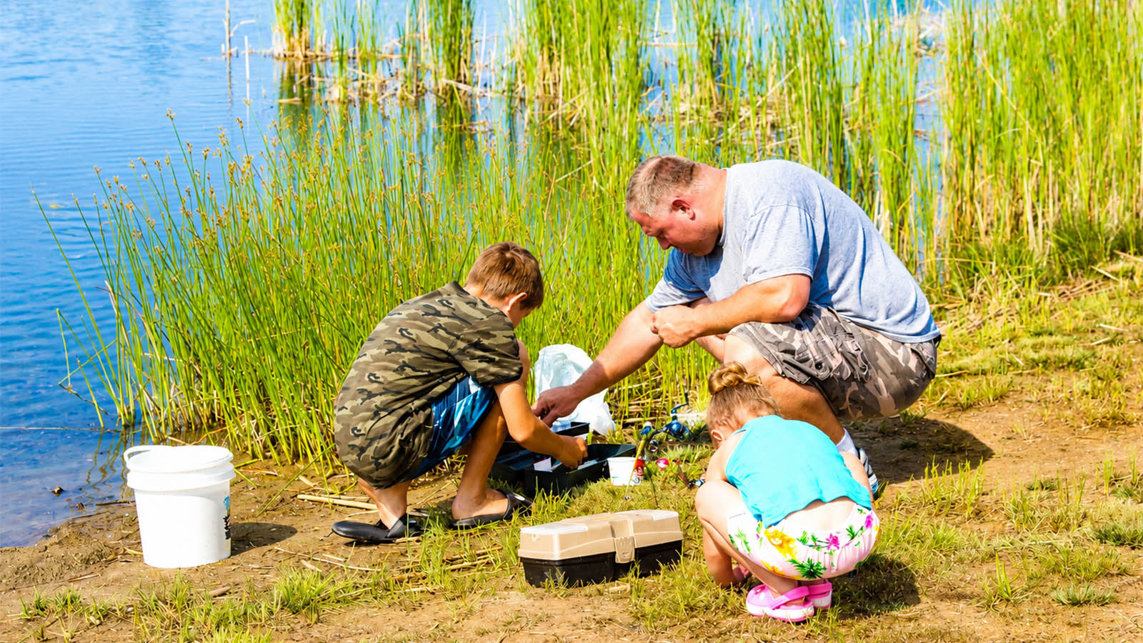 Family fishing together at Maple Lakes Campground in Seville, Ohio during the summer